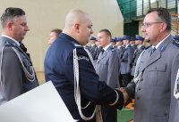 komendant wojewódzki wraz ze swoim zastępcą wręczają listy gratulacyjne nagrodzonym policjantom