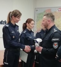 zastępca komendanta wojewódzkiego policji wręcza zwycięzcom pamiątkowy puchar