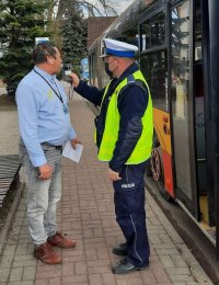 policjant kontrolujący stan trzeźwości kierowcy autobusu miejskiego