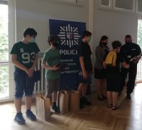 Komendant Powiatowy Policji w Pabianicach wraz z wicestarostą powiatu pabianickiego wręczają nagrody laureatom konkursu profilaktycznego.
