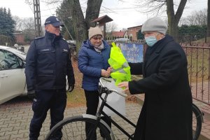 policjanci rozdają kamizelki odblaskowe na ulicy