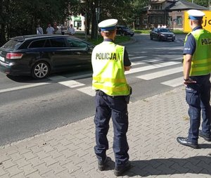 Dwóch policjantów obserwujących przejście dla pieszych.