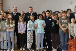 Dzieci pozują do wspólnego zdjęcia z policjantką, Komendantem Straży Miejskiej w Pabianicach, Prezesem Zarządu Ochotniczej Straży Pożarnej w Pabianicach i Starostą Pabianickim.