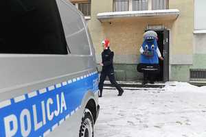Policjantka i maskotka łódzkiej Policji niosą prezenty do radiowozu.