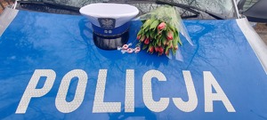 kwiaty leżące na policyjnym radiowozie.