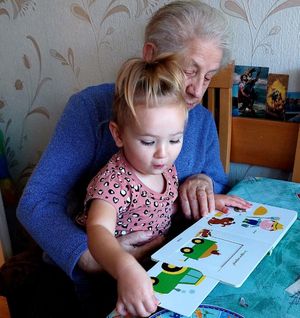 zdjęcie nadesłane przez uczestnika policyjnego konkursu organizowanego wspólnie z pabianickim kinem a na nim babcia czytająca książeczkę z wnuczką.