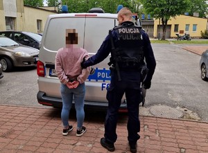 Policjant z zatrzymaną kobietą poszukiwaną listem gończym do odbycia kary pół roku pozbawienia wolności.