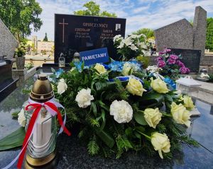 Kwiaty i znicz na grobie poległego policjanta.
