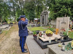 Komendant Powiatowy Policji w Pabianicach oddaje honor przed mogiłą zmarłego policjanta.