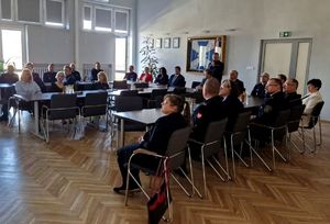 Komendant Powiatowy Policji w Pabianicach omawia prezentację, policjanci i zaproszeni goście słuchają.