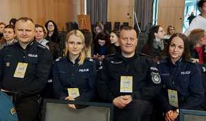 Dwóch policjantów i dwie policjantki siedzący na sali konferencyjnej.