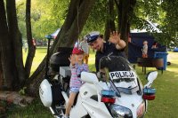 dziewczynka wraz z policjantem przy motocyklu