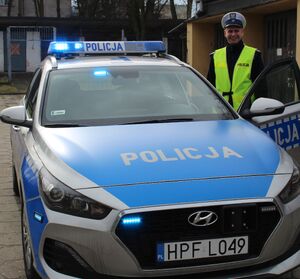 policjant stojący przy radiowozie