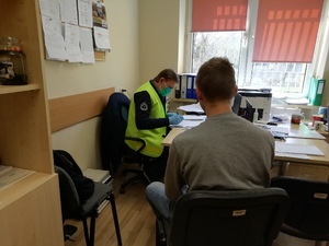 policjant przy biurku i podejrzany  siedzący obok