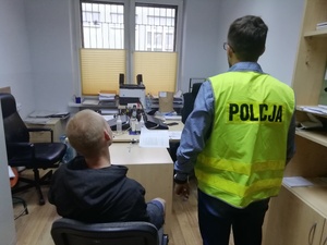 sprawca doprowadzany przez policjanta na czynności procesowe