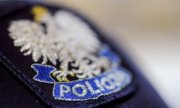 Zdjęcie dekoracyjne. Orzeł z napisem policja na granatowym tle.