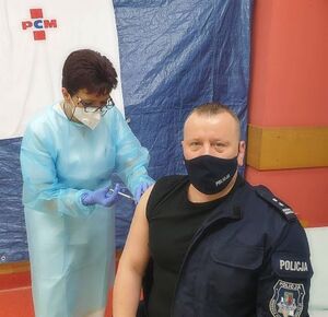 Pracownica służb medycznych szczepi Komendanta Powiatowego Policji w Pabianicach - młodszego inspektora Jarosława Tokarskiego.