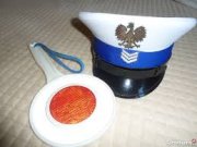 Tarcza do zatrzymywania pojazdów. Obok tarczy policyjna czapka z daszkiem.