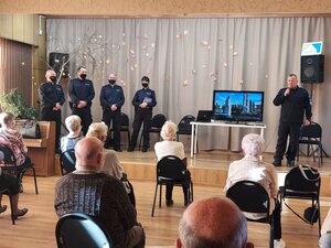 Komendant Powiatowy Policji w Pabianicach przemawia do zgromadzonych na debacie seniorów. Obok Komendanta stoją dzielnicowi z pabianickiej jednostki Policji.