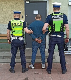 policjanci prowadzą zatrzymanego mężczyznę