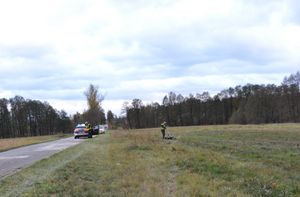 Policjanci pracujący na miejscu zdarzenia drogowego.