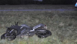 Motocykl leżący na łące.