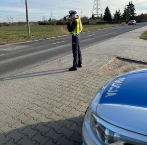 Policjantka mierzy prędkość miernikiem.