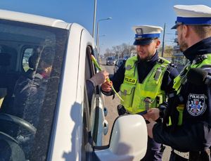 Policjanci wręczają kierującej upominek.