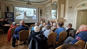 Zgromadzeni uczestnicy debaty oglądają wyświetlany film.