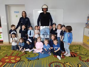 Grupa dzieci wraz  z policjantką i policjantem.