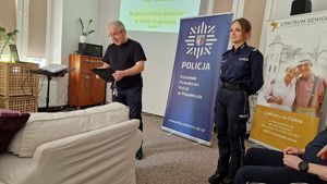 Kierownik Centrum Seniora, obok stoi policjantka prowadząca debatę.