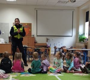 Policjantka prowadzi zajęcia z grupą dzieci.