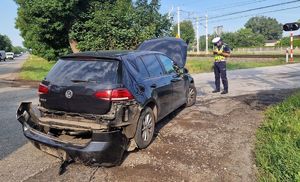 Policjant wykonujący czynności przy rozbitym samochodzie.