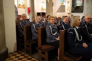 Policjanci siedzący w ławkach w kościele podczas nabożeństwa.