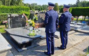 Policjanci stoją przy mogile zmarłego funkcjonariusza.