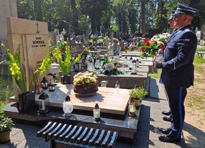 Policjanci stoją przy mogile zmarłego funkcjonariusza.