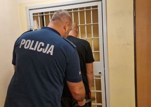 Policjant sprawdza zatrzymanego mężczyznę.