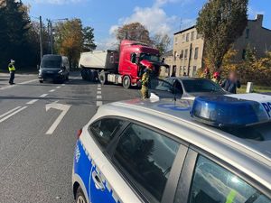 Miejsce zdarzenia na którym widać rozbite pojazdy. Na pierwszym planie znajduje się fragment policyjnego radiowozu.