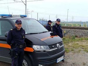 Policjanci stoją z Służbą Ochrony Kolei.