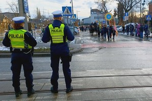 Policjant i policjantka zabezpieczają orszak.