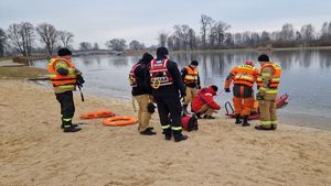 Strażacy przygotowują się na brzegu do pokazu ratownictwa na lodzie.