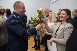 Pracownica cywilna otrzymuje różę od komendanta.
