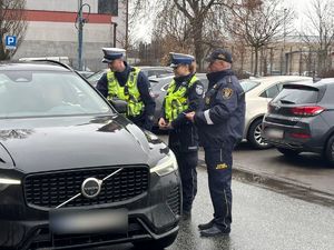 Policjanci w trakcie interwencji stoją przy samochodzie.