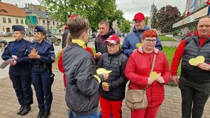 Dwie policjantki oraz grupa uczestników gry, zebrani przed Urzędem Miasta Pabianic.