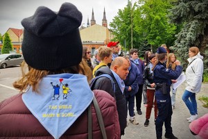 Grupa uczestników gry miejskiej stojących przed budynkiem Komendy Powiatowej Policji w Pabianicach.