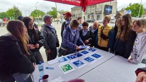 Grupa uczestników gry miejskiej wykonujących zadanie przy budynku Komendy Powiatowej Państwowej Straży Pożarnej w Pabianicach.