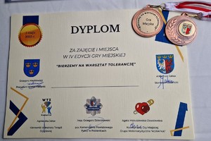 Dyplom a na nim dwa medale.