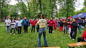 Grupa uczestników gry miejskiej stojąca przed wolontariuszką.