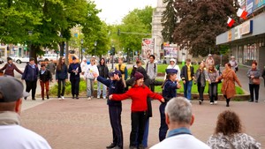 Policjantki, wolontariuszka i I Zastępca Prezydenta Miasta Pabianic stoją z wyciągniętymi dłońmi skierowanymi ku uczestnikom gry miejskiej.
