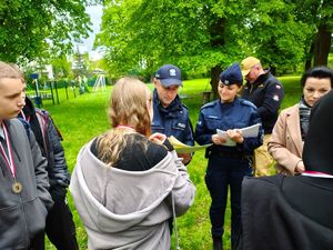 Zastępca Komendanta pabianickiej Policji wręcza uczestnikowi gry miejskiej dyplom.